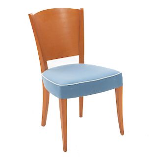 Silla. Siglo XX. En talla de madera. Con respaldo cerrado, asiento acojinado en tapicería colo azul, fustes y soportes lisos.