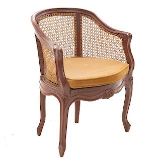Sillón. Siglo XX. En talla de madera. Con respaldo y paredes de bejuco y asiento con cojín en tapicería color marrón.