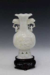 Chinese carved jade vase on wood stand.