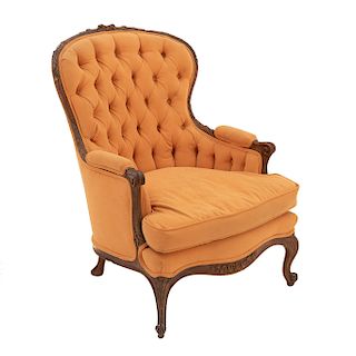 Sillón. Siglo XX. En talla de madera. En tapicería color amarillo. Con respaldo cerrado capitonado y asiento con cojín.