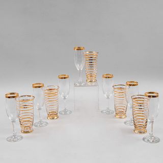 Servicio de vasos y copas. Siglo XX. Elaboradas en vidrio transparente con cenefa y anillados de esmalte dorado. Piezas: 12