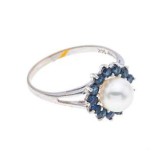 Anillo con perla y zafiros en oro blanco de 14k. 1 perla cultivada color blanco de 7 mm. 13 zafiros corte redondo. Talla: 6 1/...