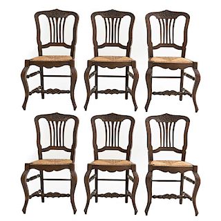 Lote de 6 sillas. Francia. Siglo XX. Estilo Luis XV. En talla de madera de roble. Con respaldos semiabiertos y asientos de palma.