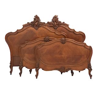 Par de camas individuales. Francia. SXX. Estilo Luis XV. En talla de madera de nogal. Con cabeceras, pieceras y 2 largueros.