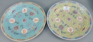 Two sets of Chinese porcelain plates, seventeen Famille Rose (dia. 10 in.) with blue ground, and thirteen with yellow ground (dia.10 in.).