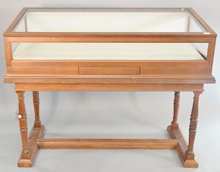 Mahogany showcase with lift top and tilting interior on trestle foot base. ht. 47 in., wd. 60 in., dp. 28 in.