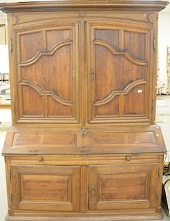 Regence provincial oak and fruitwood bureau a deux corps, the stepped rectangular cornice over a pair of wide hinged doors opening to a shelved interi