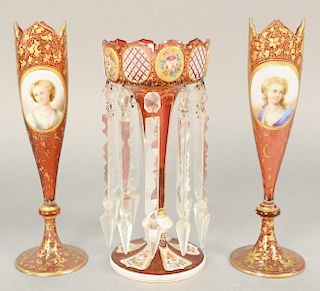 Three Victorian cranberry vases, to include a pair of vases having gilt decoration (ht. 12 in.), a portrait plaque along with a white cut to cranberry