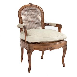 Sillón. Siglo XX. En talla de madera. Con respaldo de bejuco, asiento de bejuco con cojín en tapicería color pistache.
