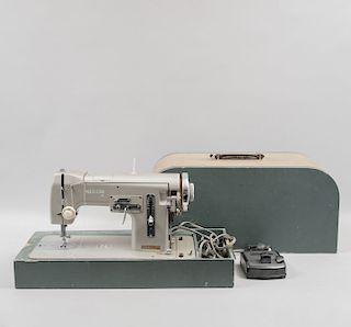 Máquina de coser en estuche. Italia, siglo XX. Elaborada en metal con base de madera de la marca Necchi. Con motor y pedal.