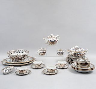 Servicio de vajilla. China, siglo XX. Elaborada en porcelana blanca con filos en esmalte dorado. Decorada con dragones. Piezas: 80