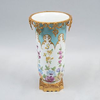 Florero. Francia, inicios siglo XX. Elaborado en porcelana pintada a mano con aplicaciones de bronce dorado.