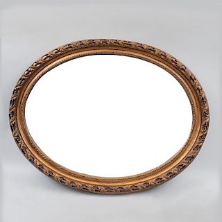 Espejo. Siglo XX. Diseño oval. Marco de resina en esmalte dorado con motivos orgánicos y luna biselada. 69 x 90 cm