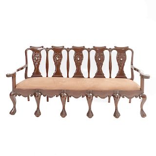 Banca. Siglo XX. Estilo Chippendale. En madera. Con respaldo semiabierto, asiento en tapicería color marrón. 100 x 213 x 60 cm.