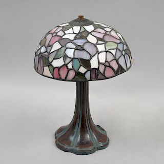 Lámpara de mesa. Siglo XX. Elaborada en antimonio con pantalla de vidrio emplomado tipo Tiffany. Para 2 luces.