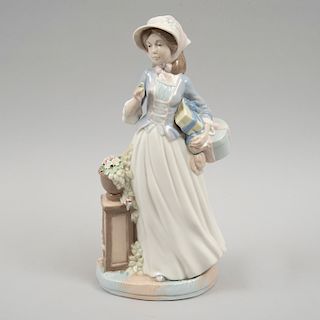 Figura de mujer con regalos. España, siglo XX. Elaborada en porcelana Nadal acabado brillante.