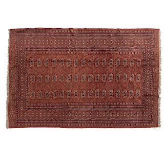 Tapete. Pakistán. Siglo XX. Estilo Boukhara. En fibras de lana y algodón. Decorado con elementos geométricos y florales. 180 x 121 cm.