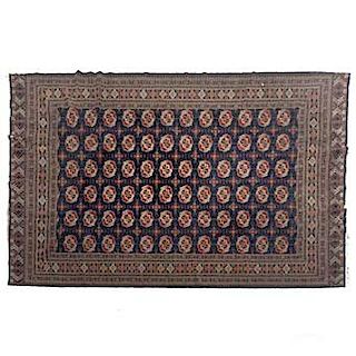 Tapete. Pakistán. Siglo XX. Estilo Boukhara. En fibras de lana y algodón. Decorado con elementos geométricos y florales. 336 x 246 cm.
