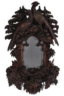 A HEAVILY CARVED BLACK FOREST MIRROR WITH BIRDS C. 1900