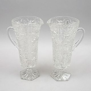 Par de jarras. Siglo XX. Elaboradas en vidrio prensado con facetados. Decorado con motivos florales y acanalados. Piezas: 2