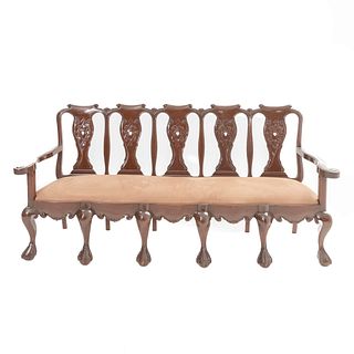 Banca. Siglo XX. Estilo Chippendale. En talla de madera. Con respaldo semiabierto, asiento en tapicería color marrón, fustes...