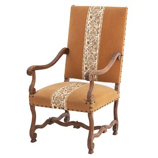 Armchair. France. 20th Century. Louis XIII. Carved in walnut. Closed backrest, upholstered in ochre-colored cloth.