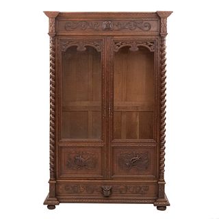 Bookcase. France. 20th Century. Carved in oak. Drawer with handle and 2 doors, one with glass. 86 x 50.7 x 17.7" (219 x 129 x 45 cm)