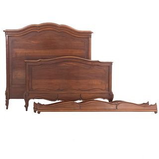 Double Bed. France. 20th Century. Louis XV. Carved in walnut. Headboard, footboard, 2 stringers, supports with wheels.