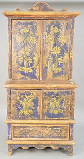 Primitive paint decorated cupboard, having two over two doors over one drawer, painted blue with yellow flower. ht. 74 in., wd. 35 in., dp. 24 in. Pro