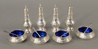 Twelve piece lot to include four open salts with blue liners, four pepper shakers and four salt spoons. 9.8 t.oz. Provenance: Estate from Sutton Place