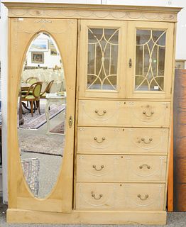 Large pine chifferobe having large door with oval mirror, two glass doors and four drawers. ht. 80 1/2 in., wd. 63 in. Provenance: Former home of Mel 