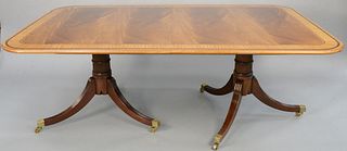 Baker Furniture mahogany double pedestal dining table having wide banded inlaid top on double pedestal base with three 19" extra leaves and custom pad
