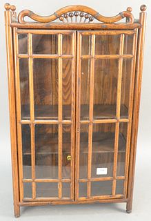 Faux bamboo hanging cabinet having two glass doors. ht. 30 in., wd. 18 in. Provenance: Former home of Mel Gibson, Old Mill Rd, Greenwich, CT