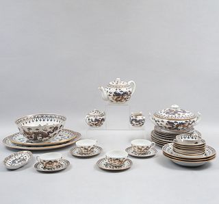 Servicio abierto de vajilla. China, siglo XX. Elaborada en porcelana blanca con filos en esmalte dorado. Decorada con dragones. Pz: 80