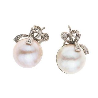 Par de aretes con dos medias perlas en plata paladio. 2 medias perlas cultivadas de color gris de 16 mm. 14 acentos de diamantes.