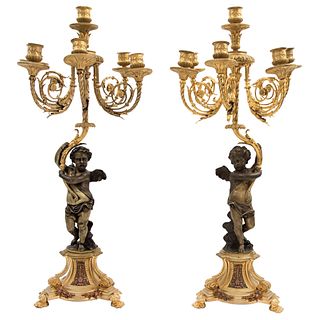 Pair of Candlesticks. France(?). 18th Century. Golden bronze and cherub stems. Base decorated with vegetable motif.