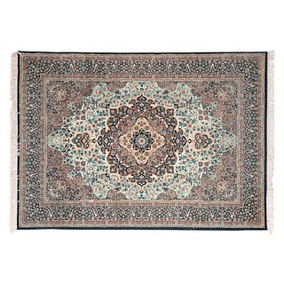 Tapete. Siglo XX. Estilo Mashad. Elaborado en fibras de lana y algodón. Decorado con motivos florales y orgánicos. 170 x 236 cm.