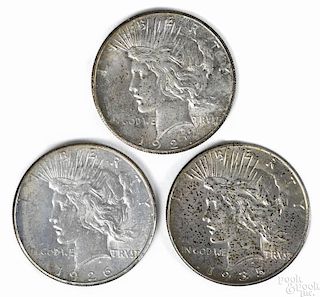 Three silver Peace dollars, to include a 1926 S, UNC, a 1927, UNC, and a 1935, UNC.