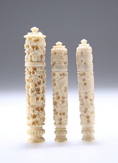 THREE 19TH CENTURY CHINESE IVORY NEEDLE CASES, comprising a pair carved wit