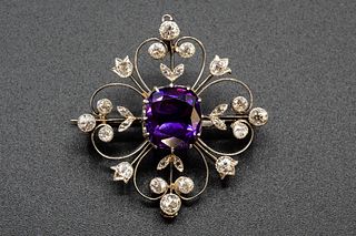 AN AMETHYST AND DIAMOND BROOCH, the central cushion cut amethyst set to the
