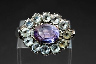 AN AMETHYST AND PASTE RING, the oval cut amethyst set within a surround of 