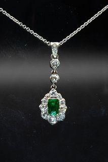 AN EMERALD AND DIAMOND PENDANT, the rectangular cut emerald set within a su