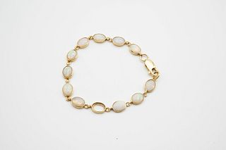 AN 18CT YELLOW GOLD AND OPAL BRACELET, the twelve oval opals (one lacking) 