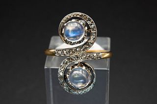 A MOONSTONE AND DIAMOND SET RING, the unusual mount of a double spiral set 