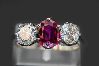 A BURMESE RUBY AND DIAMOND PLATINUM  RING, the oval cut ruby set between tw