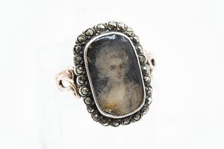 A GEORGIAN CUT-STEEL SET MOURNING RING, the oval mount with glass locket en