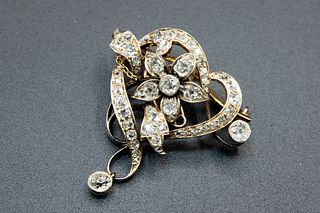A DIAMOND SET BROOCH, the coiled abstract heart shaped mount, to the centre