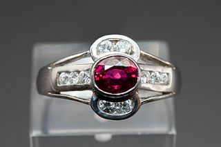 AN 18CT WHITE GOLD, RUBY AND DIAMOND RING, the oval cut ruby to the centre 