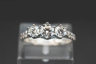 A THREE STONE DIAMOND RING, the three graduating brilliant cut diamonds set