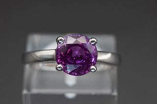AN 18CT WHITE GOLD AND PURPLE SAPPHIRE RING, set simply with a round cut pu